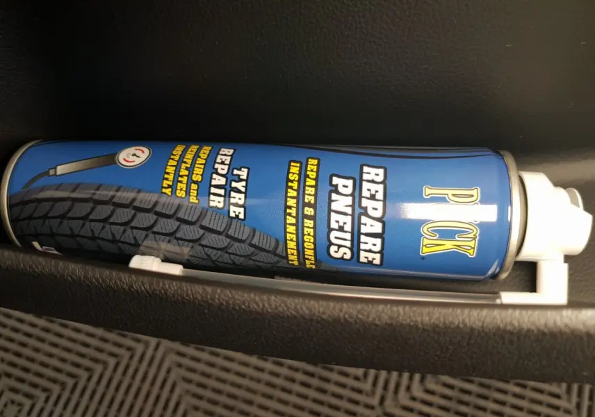 Image ne montrant pas le véhicule AIXAM AMBITION 0.5 CITY SPORT bleu, mais un produit de réparation pneus dans un rangement intérieur.