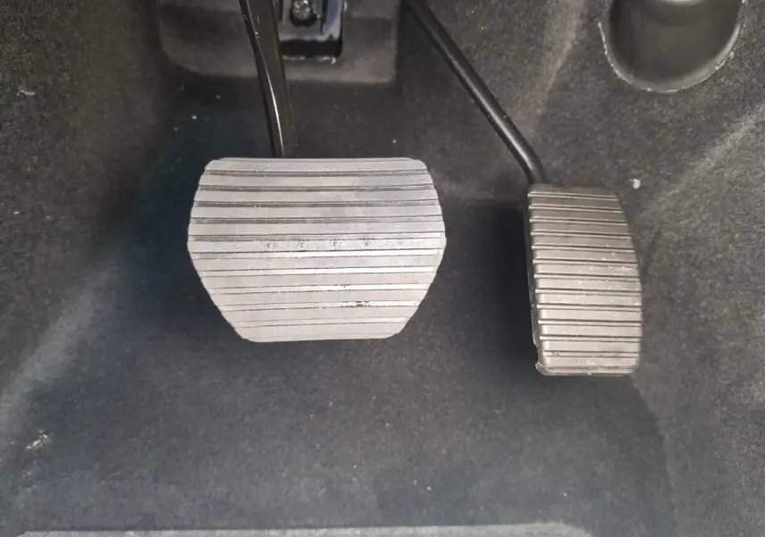 Gros plan sur les pédales d’accélérateur et de frein de l’AIXAM AMBITION 0.5 CITY SPORT 2026, intérieur noir.