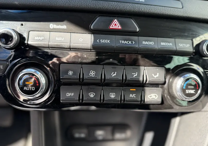 Vue rapprochée du tableau de bord du Kia Sportage 1.6 CRDI 136 Black Edition, montrant les commandes de climatisation et multimédia.