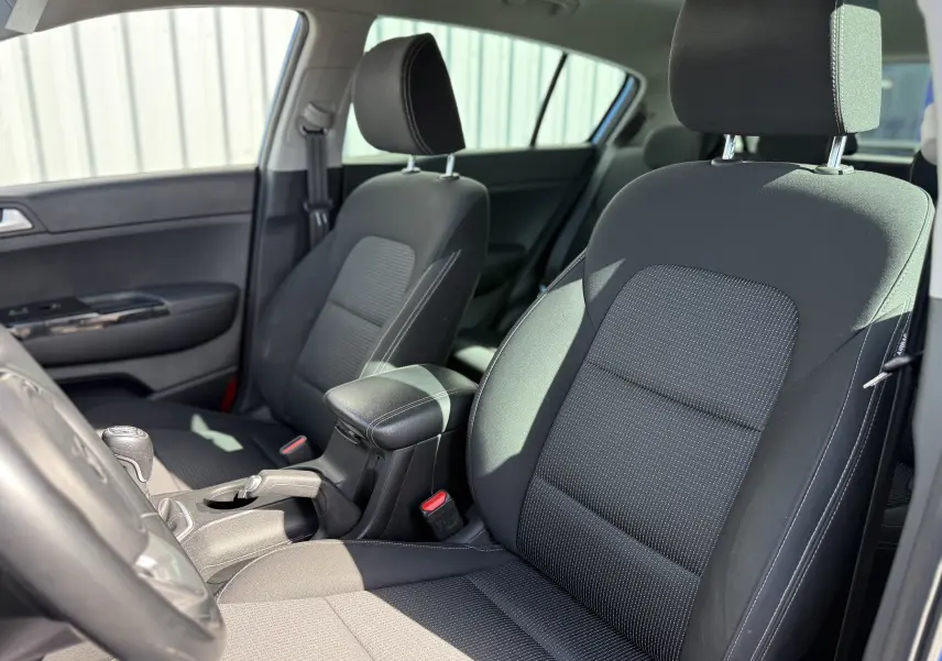 Vue intérieure côté avant droit du Kia Sportage 1.6 CRDI 136 Black Edition 2021 avec sièges tissu noirs et boîte manuelle.