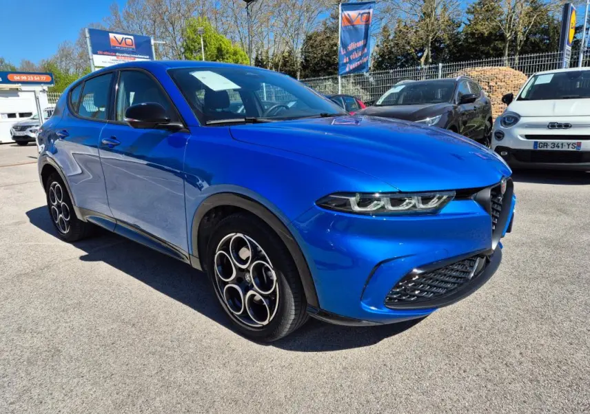 Vue 3/4 avant gauche d'une Alfa Romeo Tonale 1.5 Hybrid bleu 2025 avec jantes alliage 18 pouces et rétroviseurs noirs.