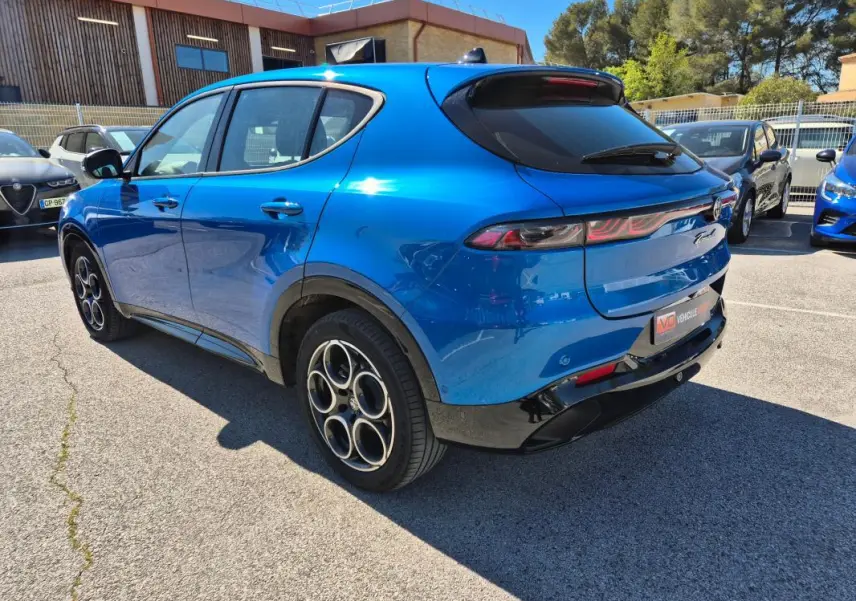 Vue 3/4 arrière droite d'une Alfa Romeo Tonale bleu 2025 avec jantes alliage 18 pouces et feux arrière fins.