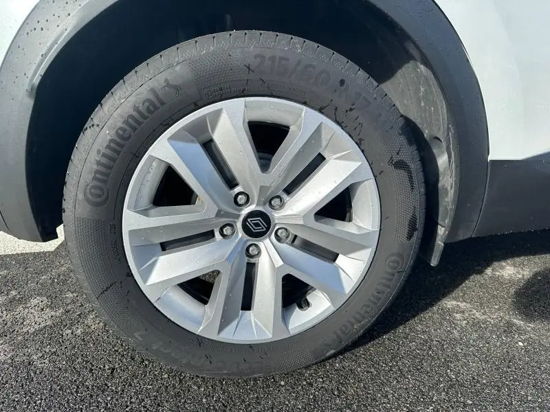 Gros plan sur la roue avant droite du Renault Captur blanc nacré avec jante alliage argentée et pneu Continental.
