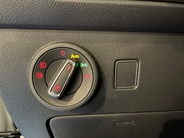 Gros plan sur le bouton de commande des phares du SEAT Ateca 2017, intérieur noir texturé.