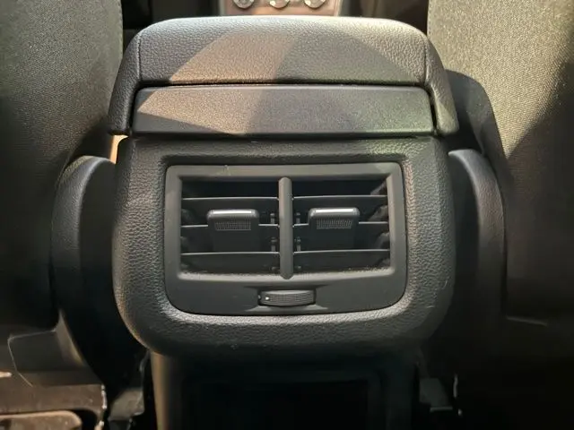 Gros plan sur la sortie d'air arrière noire du siège central d'un SEAT Ateca blanc Nevada de 2017.