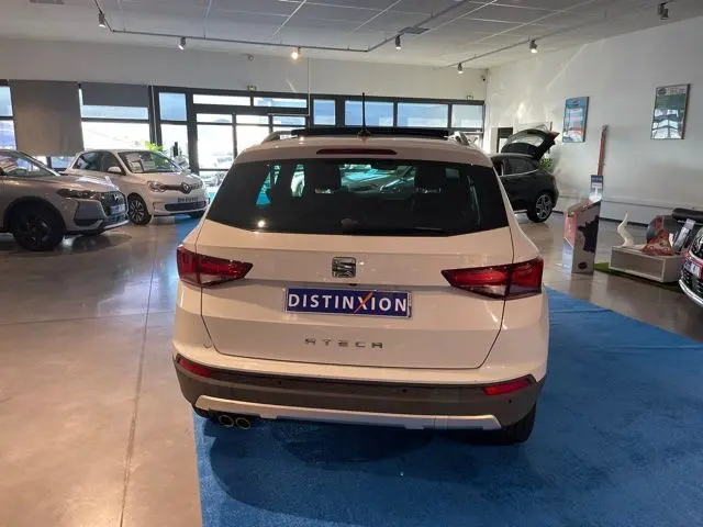 Vue arrière d'un SEAT Ateca blanc Nevada exposé en showroom avec double sortie d'échappement et plaque Distinxion.