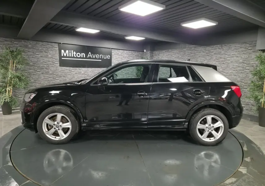 Audi Q2 noir vue de profil côté gauche avec toit contrasté argent et jantes 5 branches en étoile.