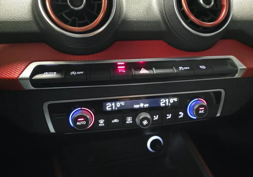 Détail du tableau de bord de l'Audi Q2 2017 avec commandes de climatisation et décorations rouges intérieures.
