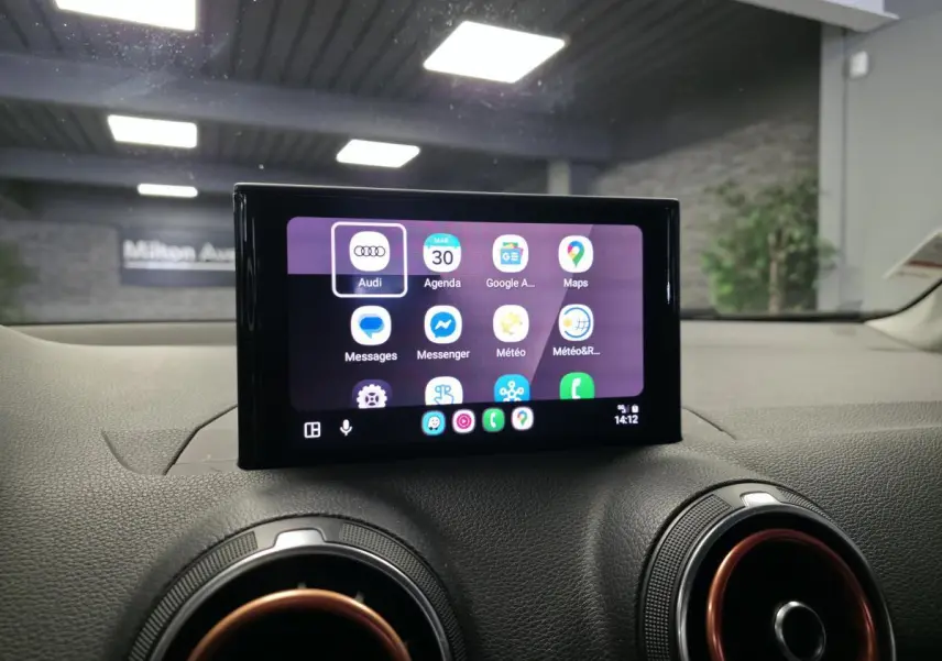 Écran tactile MMI central affichant applications connectées, entouré de buses d'aération avec cerclage rouge dans Audi Q2 noir 2017.