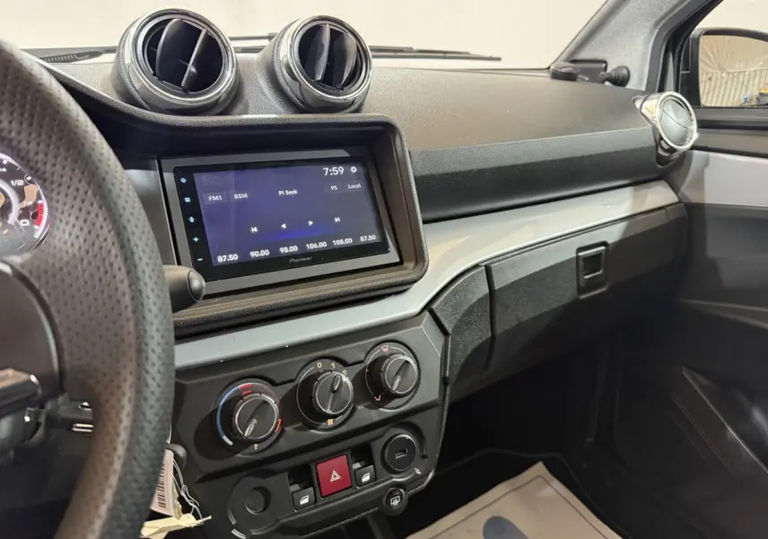 Vue intérieure de la planche de bord de l'AIXAM Ambition 0.5 Crossover Premium avec écran tactile et commandes manuelles.