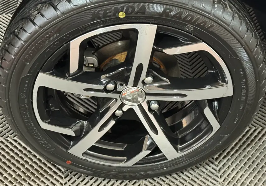 Gros plan sur la jante noire et argentée d'une Aixam Ambition 0.5 Crossover Premium gris foncé, roue avant.