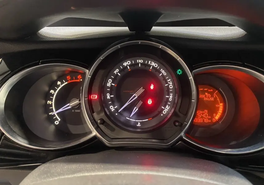 Vue rapprochée du tableau de bord de la Citroën DS3 1.6 E-HDI, avec compte-tours, compteur et affichage digital rouge.