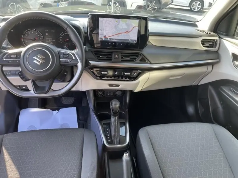 Vue intérieure avant de la Suzuki Swift 2024 avec tableau de bord moderne, écran tactile central et volant multifonction.