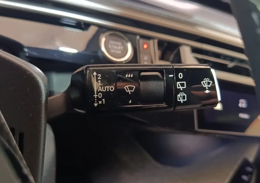 Gros plan sur la commande des essuie-glaces du Peugeot 5008 gris clair, avec bouton démarrage en arrière-plan.