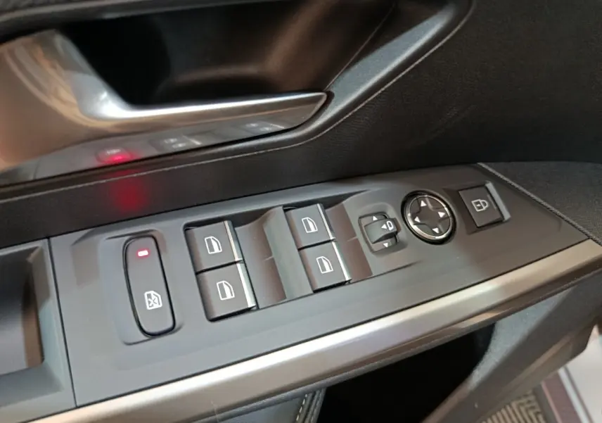 Détail des commandes de lève-vitres et rétroviseurs côté conducteur du Peugeot 5008 gris clair, intérieur noir.