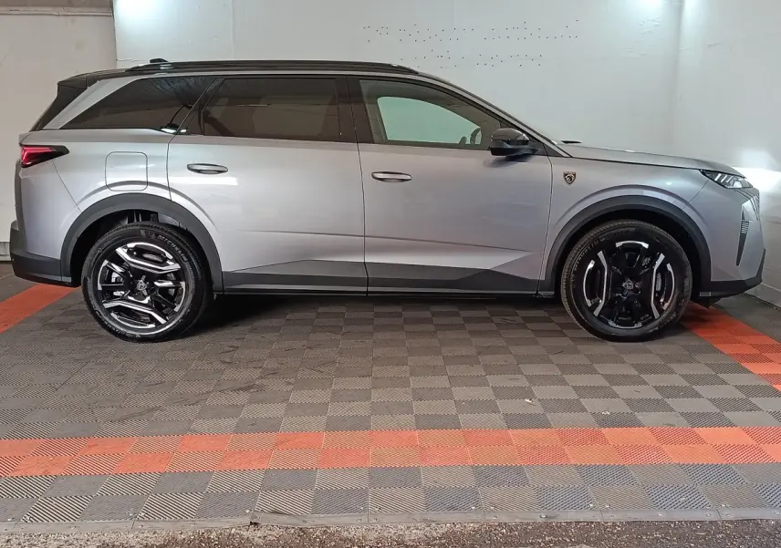 Peugeot 5008 gris clair vue de profil côté gauche, SUV hybride rechargeable avec jantes noires brillantes.