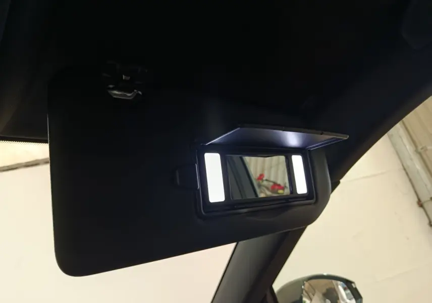 Détail du pare-soleil intérieur noir avec miroir éclairé dans un Peugeot 5008 gris clair, vue côté passager.