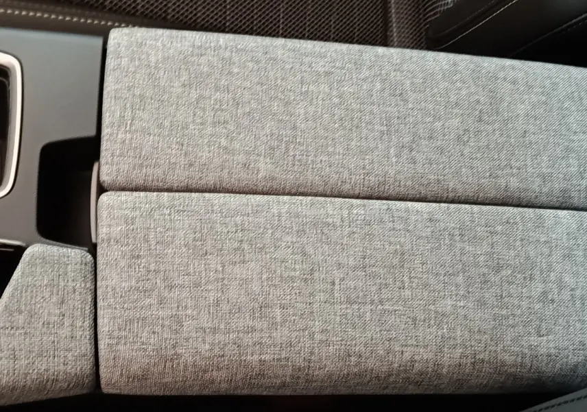 Détail de l'accoudoir central en tissu gris clair à l'intérieur du Peugeot 5008 1.6 PHEV 195 E-DCS7 GT 2026.