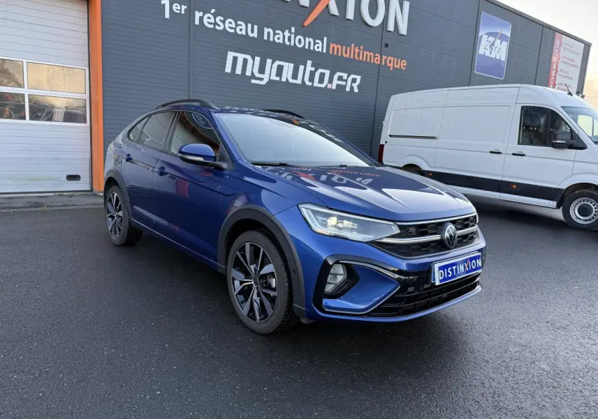 Volkswagen Taigo bleu récif métallisé en 3/4 avant droit avec jantes noires brillantes et calandre R-Line.