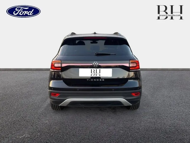 Vue arrière d'un Volkswagen T-Cross noir intense nacré avec feux arrière LED et logo central visible.