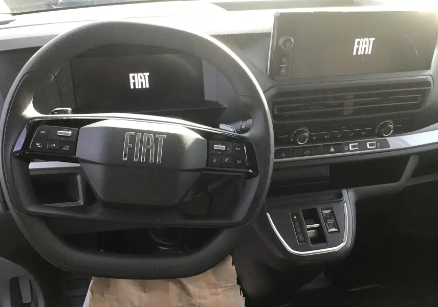 Vue intérieure centrée sur le volant et tableau de bord noir du Fiat Scudo Fourgon 2024 avec écran tactile FIAT.