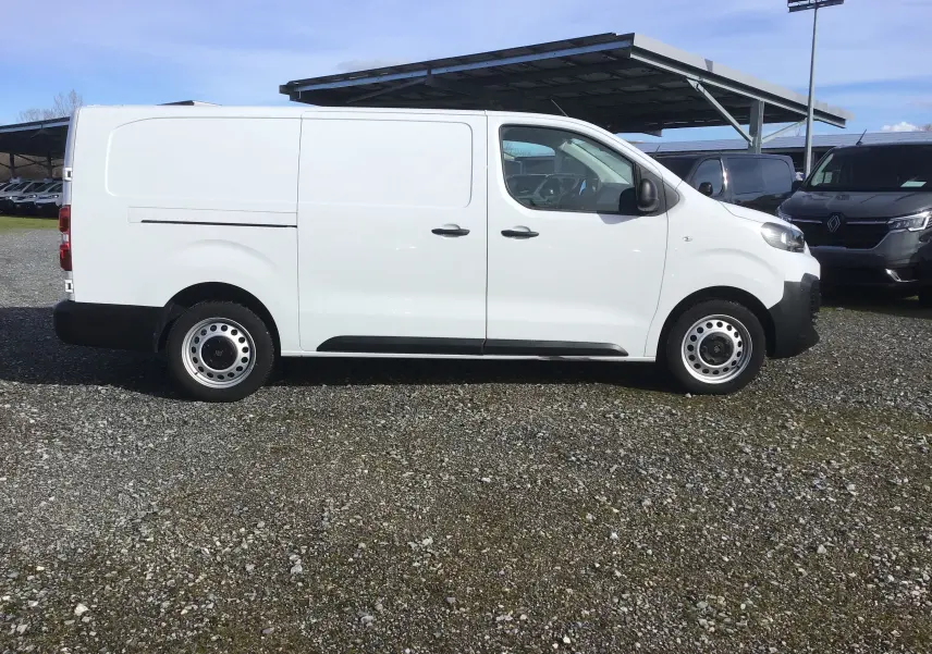 Vue de profil côté gauche d’un FIAT Scudo Fourgon blanc 2024 avec garde au sol réhaussée et jantes acier.