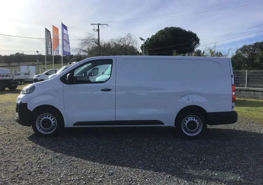 Vue latérale gauche d’un FIAT Scudo Fourgon blanc 2024, version XL avec garde au sol réhaussée et plaque de protection tôlée.
