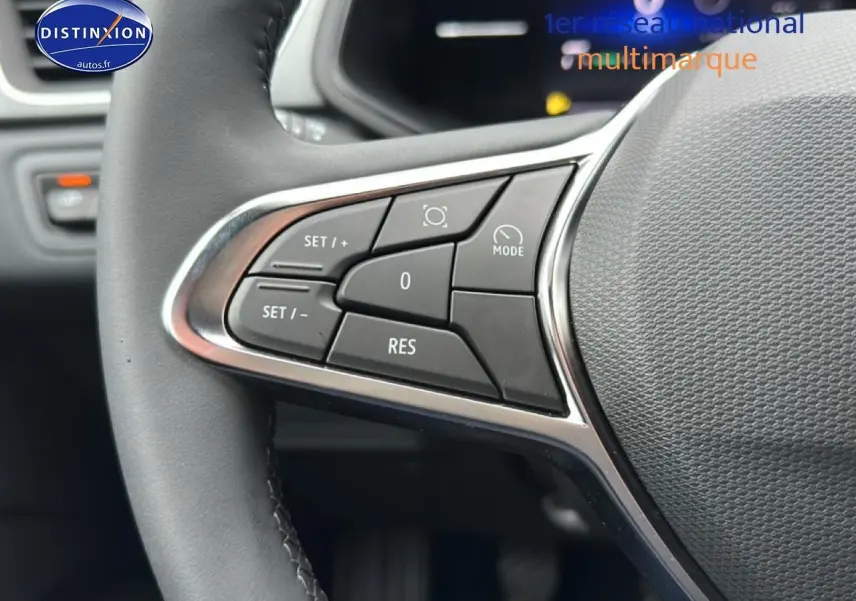 Gros plan sur les commandes multifonctions à gauche du volant du Renault Captur gris rafale, intérieur moderne.