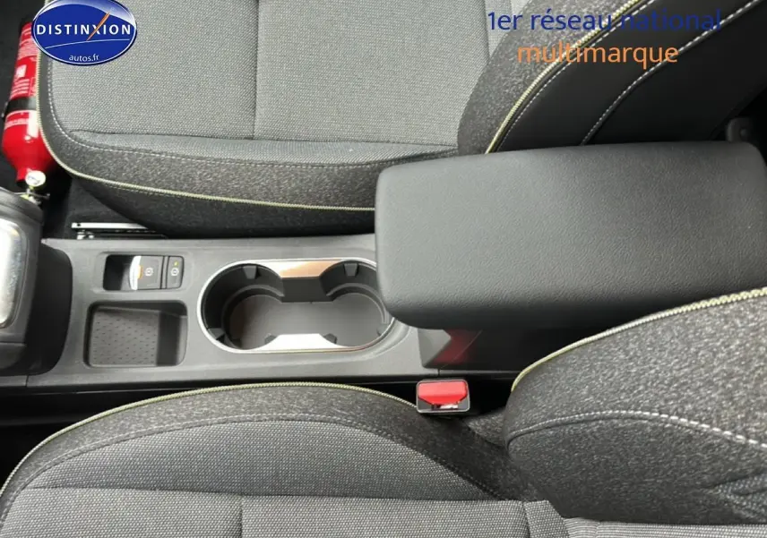 Vue plongeante sur l'accoudoir central et les sièges en tissu gris du Renault Captur 2025 finition Techno.