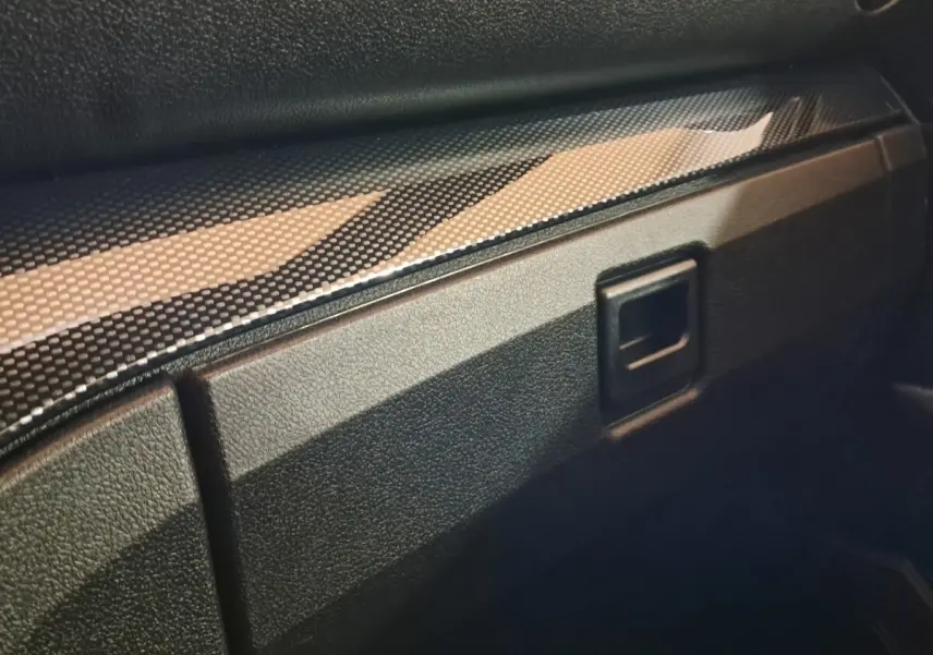 Détail intérieur du tableau de bord noir texturé avec insert imitation carbone de l'AIXAM AMBITION 0.5 CITY COUPE GTI blanc.