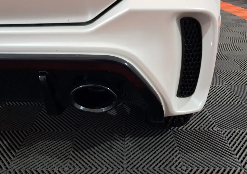 Gros plan sur l'arrière droit blanc de l'AIXAM AMBITION 0.5 CITY COUPE GTI 2026 avec sortie d'échappement et grille noire.