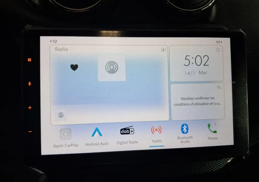 Écran tactile central de l'AIXAM AMBITION 0.5 CITY COUPE GTI blanc, affichant les options radio et connectivité.