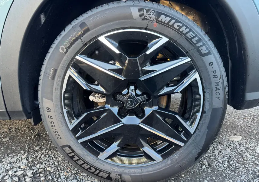 Gros plan sur la roue avant droite du Peugeot 3008 Hybrid 2025 avec jante noire et argent et pneu Michelin.