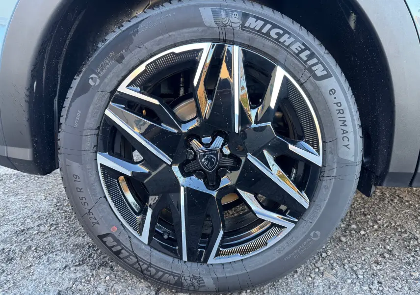 Gros plan sur la jante avant droite noire et argentée du Peugeot 3008 Hybrid 136ch Bleu Nogaro avec pneu Michelin.