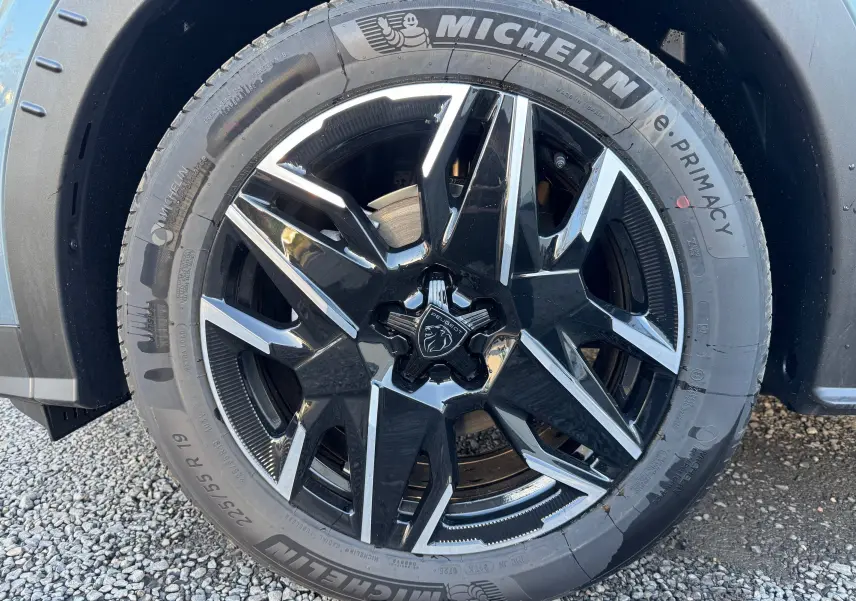 Gros plan sur la jante noire et argentée du Peugeot 3008 Bleu Nogaro, mettant en valeur le logo lion central.