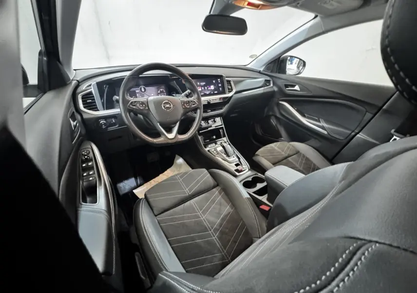 Intérieur de l’Opel Grandland 2022 vu côté conducteur, volant cuir, écran tactile et sièges tissu noir.