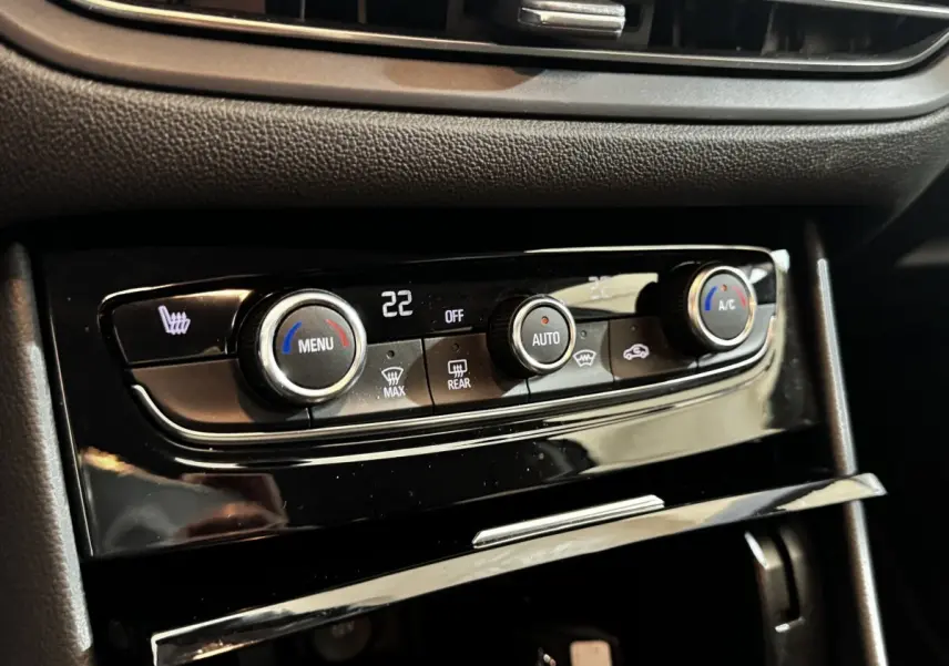 Gros plan sur la commande de la climatisation automatique bi-zone du tableau de bord noir d’un Opel Grandland gris clair.