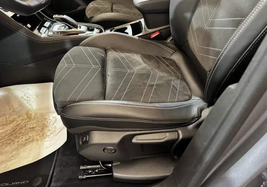 Gros plan sur le siège avant droit en cuir et alcantara noir avec surpiqûres blanches de l’Opel Grandland gris clair.