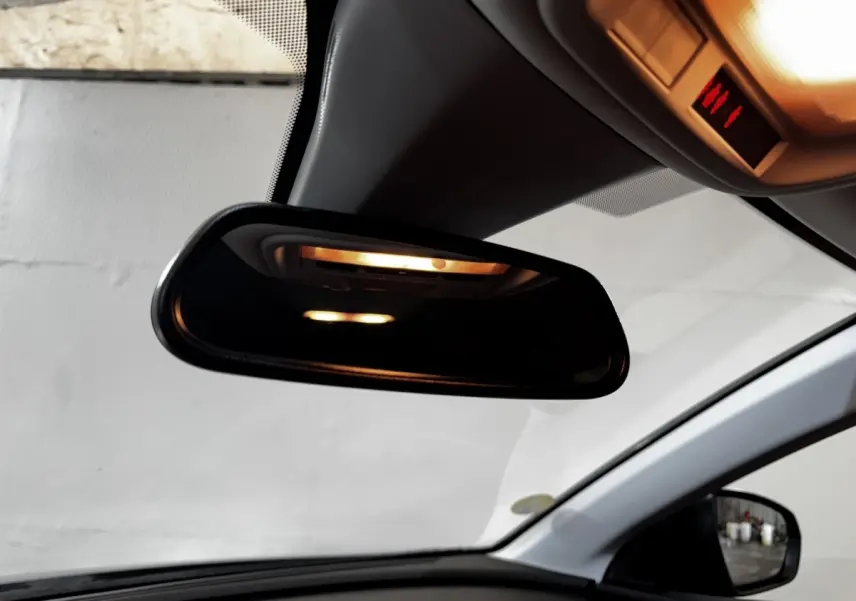 Vue intérieure centrée sur le rétroviseur intérieur et le plafond clair d’un Opel Grandland gris clair 2022.
