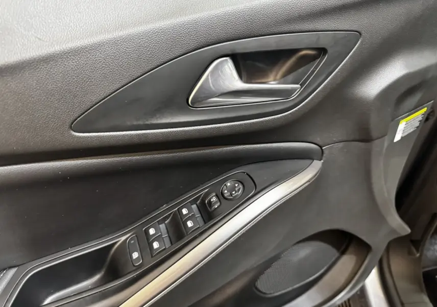 Gros plan sur la porte intérieure côté conducteur de l’Opel Grandland 2022, avec commandes de vitres et poignée argentée.