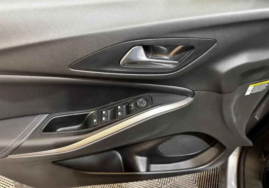 Gros plan sur la porte avant gauche noire de l'Opel Grandland 2022 avec commandes de vitres et poignée métal.