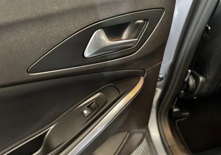 Gros plan sur la porte arrière droite intérieure gris clair de l'Opel Grandland avec poignée et commande de verrouillage.