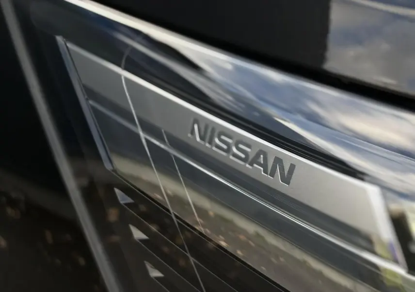 Gros plan sur la calandre noire métallisée du Nissan Primastar Combi 2025 avec logo Nissan argenté visible.