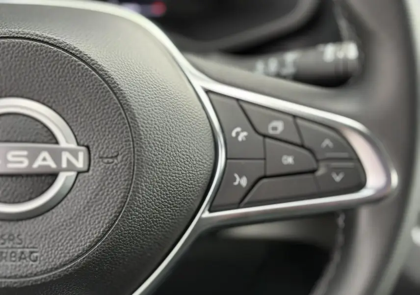 Gros plan sur les commandes multifonctions à droite du volant noir du Nissan Primastar Combi 2025.
