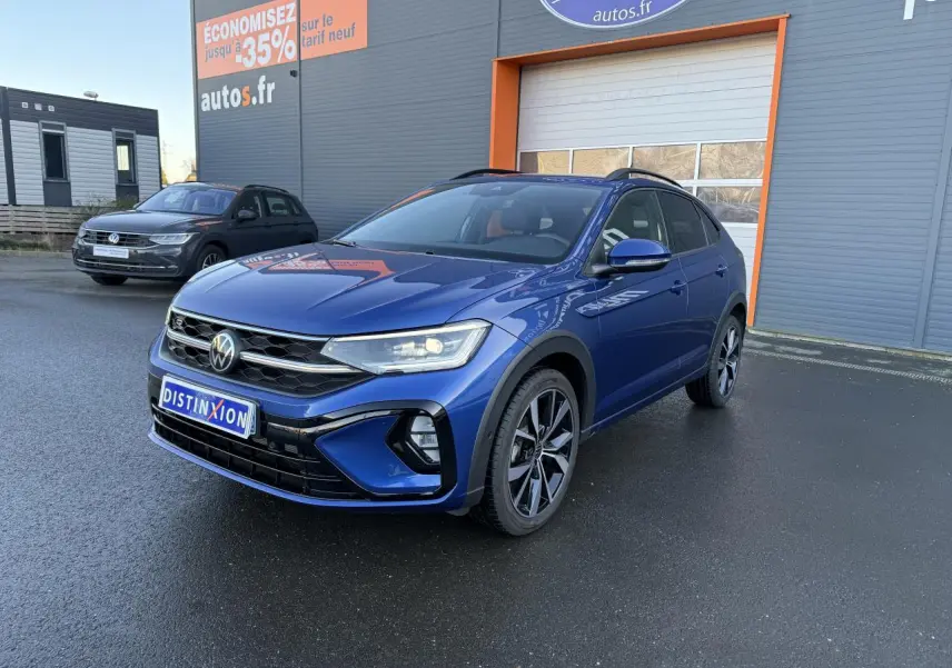 Volkswagen Taigo bleu récif métallisé en 3/4 avant droit avec jantes noires brillantes et calandre R-Line.