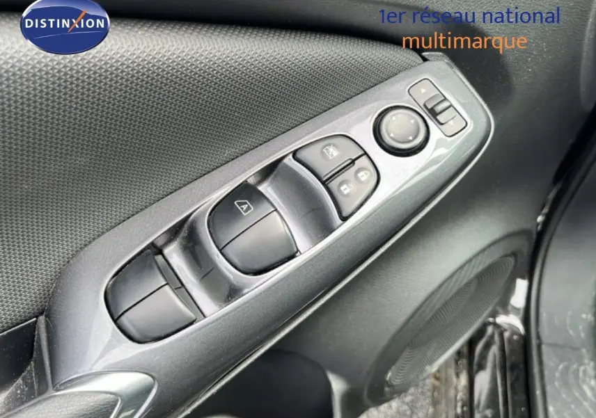 Gros plan sur la commande des vitres et rétroviseurs côté conducteur du Nissan Juke noir métal 2023.