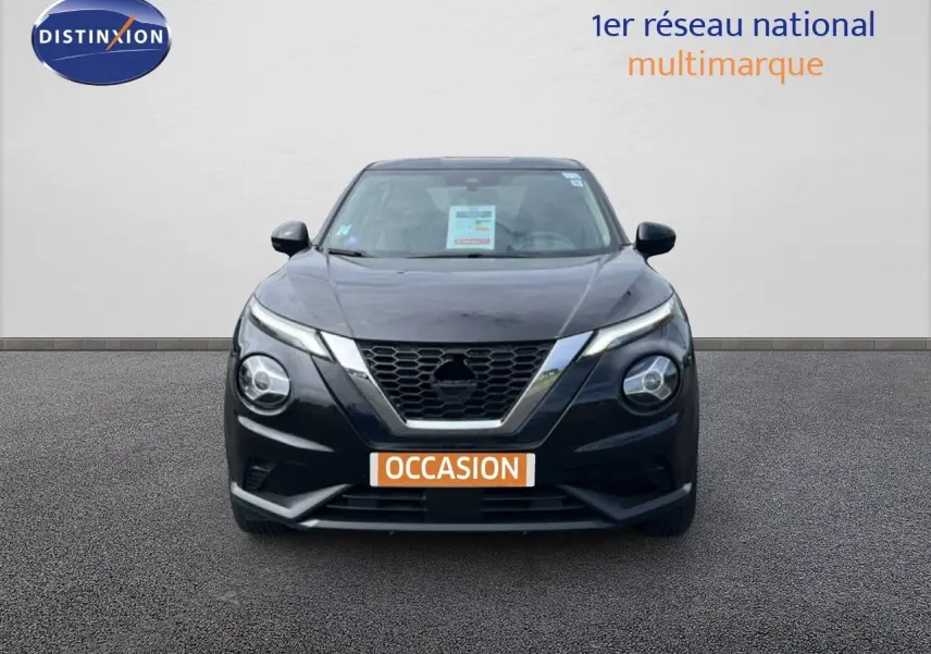 Vue avant d'un Nissan Juke noir métal 2023 avec calandre en V chromée et phares ronds distinctifs.