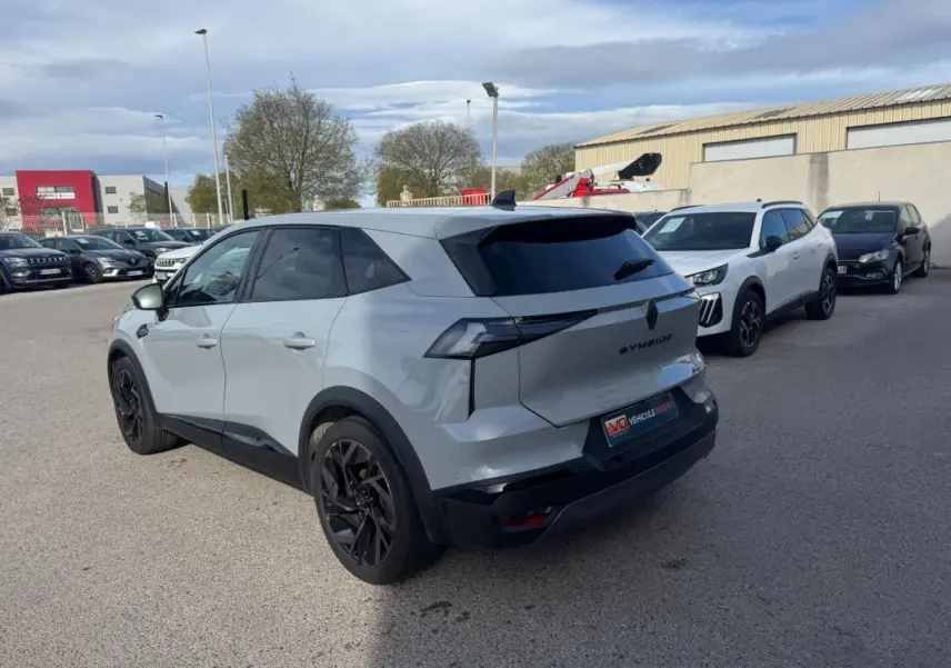 Vue 3/4 arrière droite d’un Renault SYMBIOZ gris clair avec jantes alliage noires de 19 pouces, stationné en extérieur.
