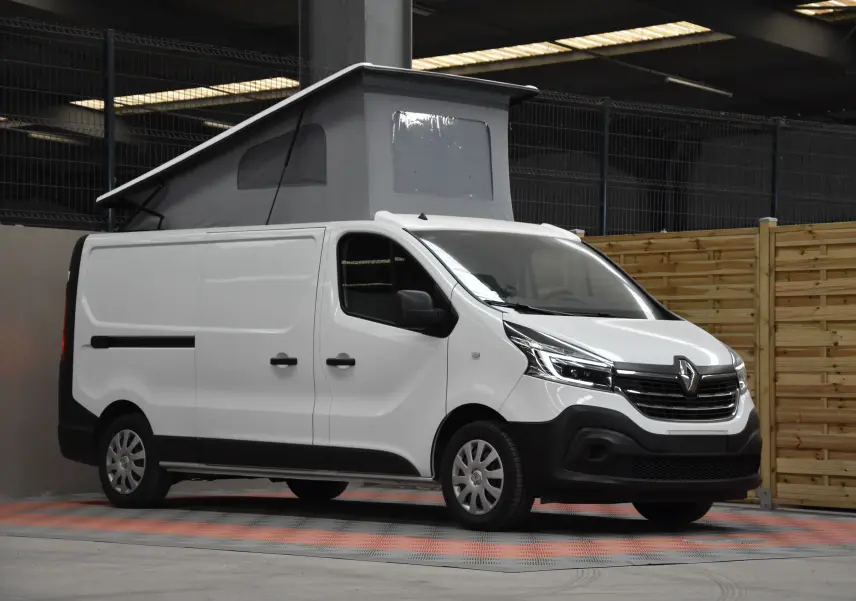 Renault Trafic Combi blanc en 3/4 avant droit avec toit relevé et carrosserie utilitaire visible en intérieur.