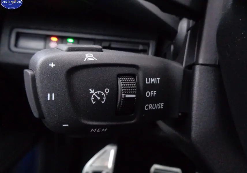 Gros plan sur la commande de régulateur de vitesse du Peugeot 3008 gris Artense, avec molette et symboles blancs.